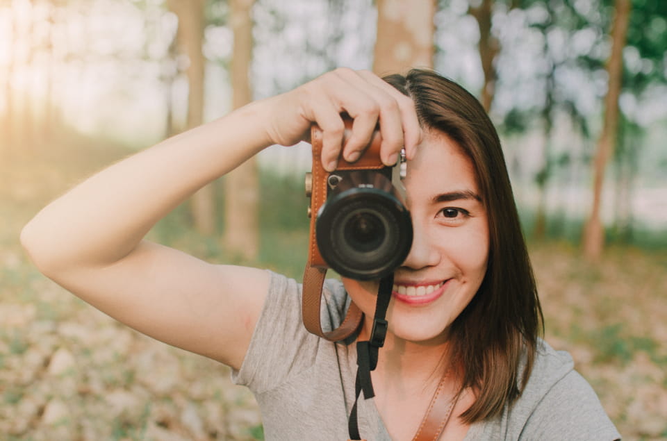 woman taking a photo in a forrest