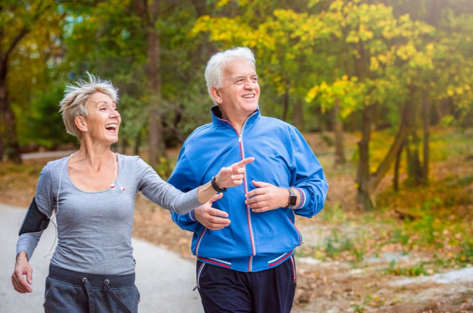 Older couple out for a jog pointing to something interesting in the distance