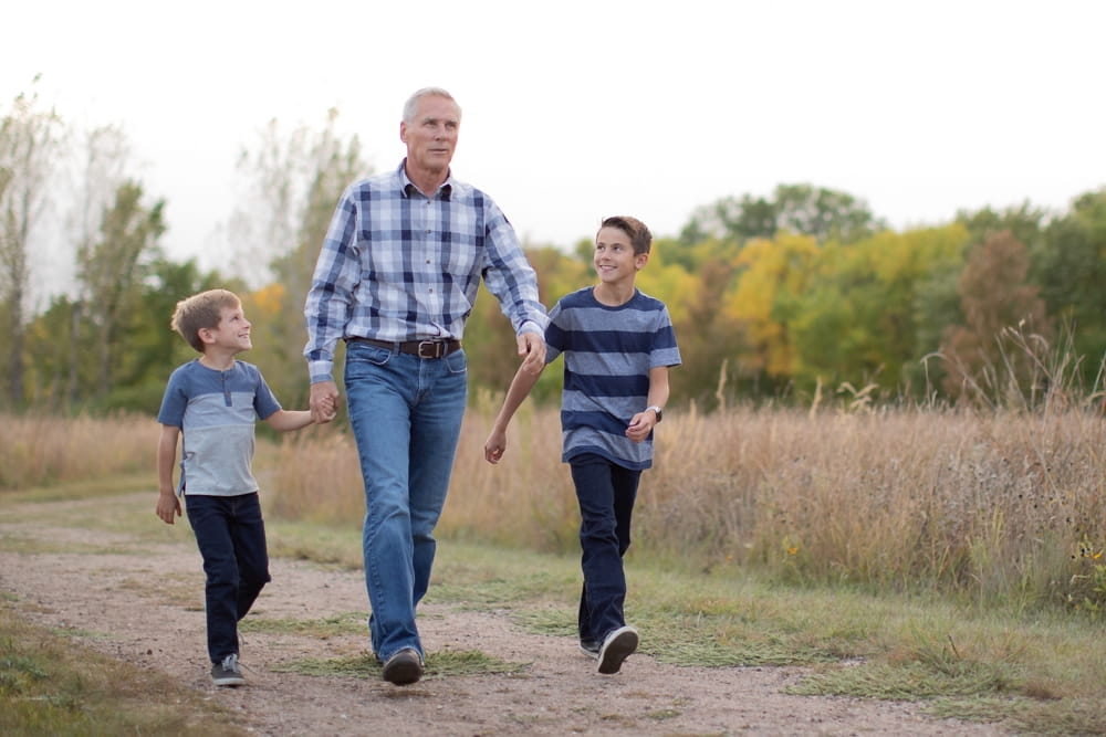 Grandpa walking happily with his two grandsons