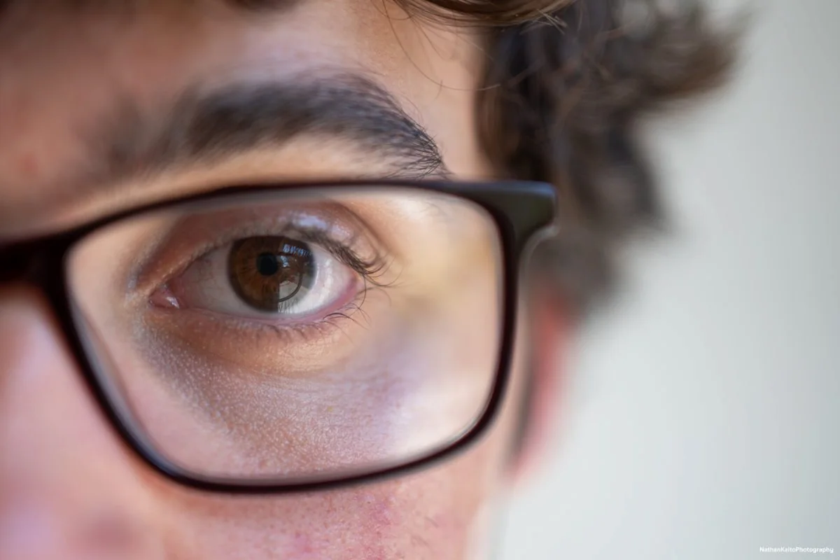 man wearing glasses looking into the camera closely